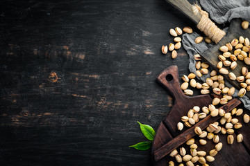 Pistachios on a black background. Top view. Free space for your text.