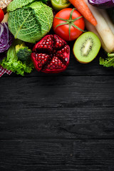 Fresh vegetables and fruits. Organic food on a black wooden background. Top view. Free copy space.