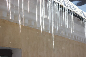 Water drops on the roof. icicles melt under influence of warm air and sun. Spring influence in the world. Modifying the pores of the years. The sun's rays change aggregate state of ice to water