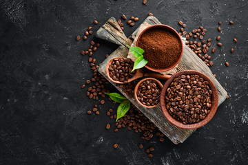Ground coffee and coffee beans. Assortment of coffee varieties on a black background. Top view. Free space for your text. - obrazy, fototapety, plakaty