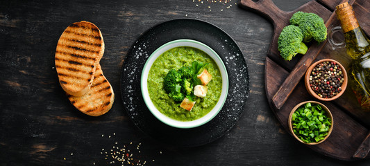 Broccoli, spinach cream soup in a bowl with toasted bread. Green soup. Dietary food. Top view.