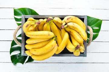 Fresh bananas in a wooden box. Top view. Free copy space.