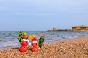 Weihnachtliche Figuren aus Mandarinen und Gewürzen am Strand und Meer