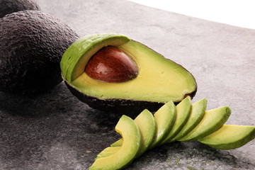 Avocado on old table. Halfs of avocado. Fruits healthy food concept
