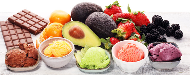 Set of ice cream scoops of different colors and flavours with berries, chocolate and fruits.