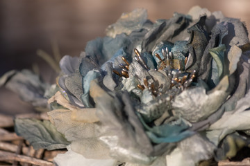 Silk rose on old chair in summer evening in garden. Blurred background and natural silk rose of soft focus for creative hobby. Toned Image does not focus.