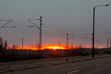 Fototapeta na wymiar Beautiful sunrise at road and railroad at autumn in Finland.