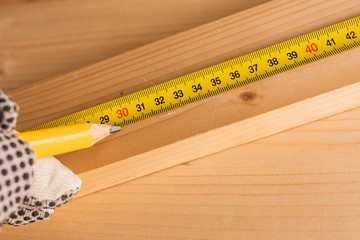 Carpenter marking pine wood plank for cutting