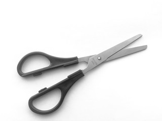 Scissors with a black handle on a white background lie on the table