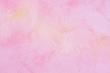 Pink decorative plaster textured background with yellow and beige abstract spots and grunge surface. Empty neutral pink backdrop with decorative plastered texture and aged effect 