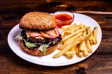 Close up to beef burger with cheese and vegetables.