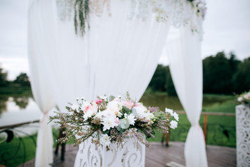 Decorated arc with flowers for the wedding ceremony on the shore of the lake