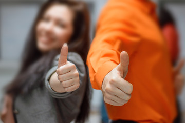 Man and woman hold thumbs up.