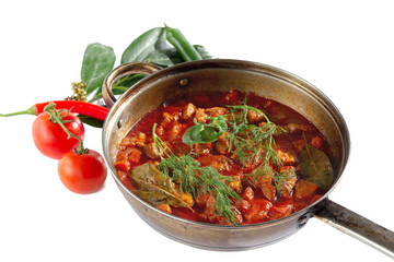 stewed meat with vegetables in tomato sauce on pan isolated on white background