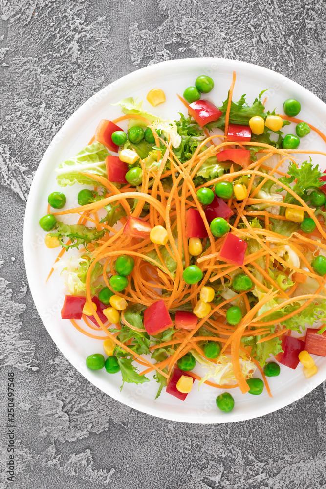 Wall mural fresh vegetable salad with raw carrot, green peas, corn, sweet pepper and lettuce. healthy vegan, ve