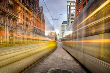 Fototapeta na wymiar Yellow fast moving Metrolink tram in Manchester City