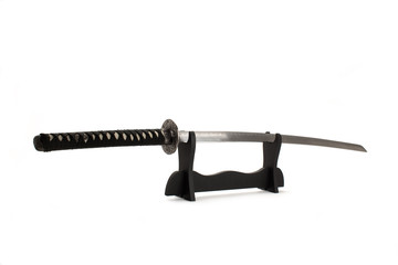 Vintage katana sword on black wodden stand isolated on white background.