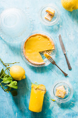 Lemon curd tartelette over a blue concrete background, top view.Pastry base is a simple Paté Sucré, filled with lemon curd.