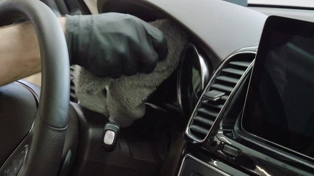 Car wash and detailing. A man cleaning the car interior of luxury modern automobile. 4K
