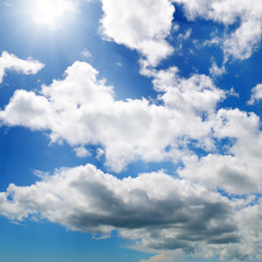 Naklejka na ściany i meble Sun on blue sky with white clouds.