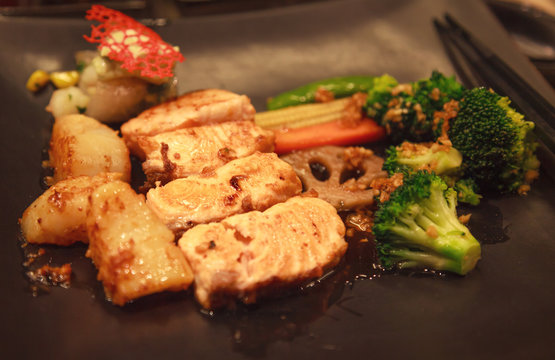 Fresh Assorted Seafood, Salmon Fillet, Scallop and Vegetable Teppanyaki Grill (Japanese cuisine that uses an iron griddle or hot fry pan to cook food) in traditional steakhouse. Food Cooking concept