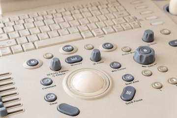 Close-up of the control panel of the ultrasound machine. Background of modern medical diagnostic equipment. Gray and white buttons.