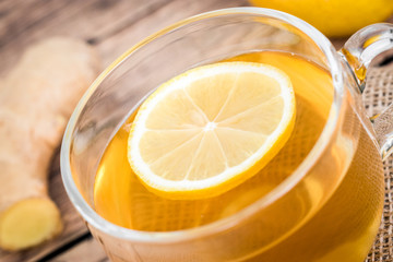 Closeup of a cup of tea with lemon slice and fresh ginger