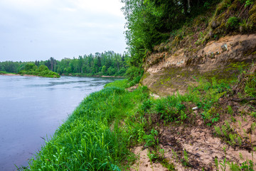 sandstone cliffs on the shore of forest river
