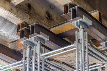 Metal beams and support scaffolding reinforce the concrete span of the bridge.