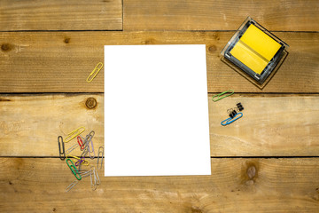 Sticky note dispenser with paperclips and blank vertical 8.5x11 for your copy on distressed wooden background