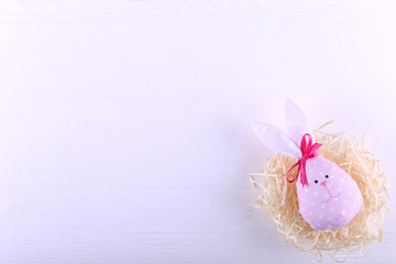 Pink hare in the nest, copy space. Happy Easter concept greeting card design.