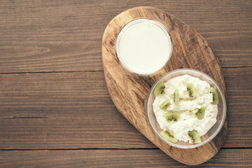 Top view curd with kiwi milk glass on wooden stand. copy space, flat lay