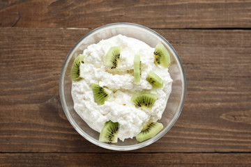 Top view close-up of curd and kiwi wooden background, healthy Breakfast