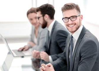 Fototapeta premium side view. smiling businessman on the background of the workplace