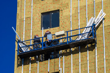 Facing the building with a ventilated facade. Aluminum colored facades. Modern facades of high-rise...