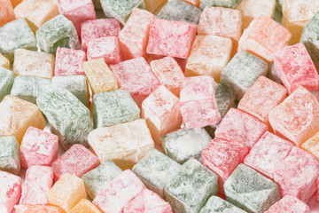 Pieces of multicolored Turkish Delight in powdered sugar.