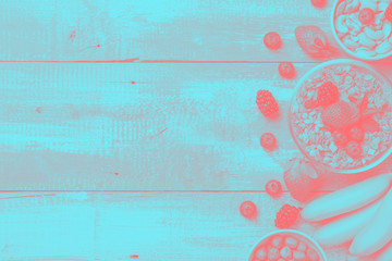 Muesli, nuts, fruits, berries, banana on wooden rustic background. Healthy food concept, doutone...