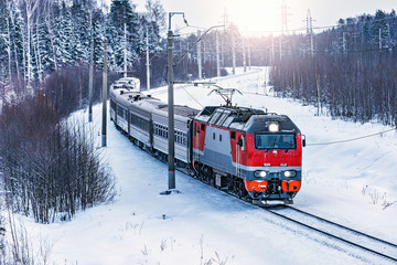 Passenger train approaches to the station at cold winter morning time. Fryazevo. Moscow region. Russia.