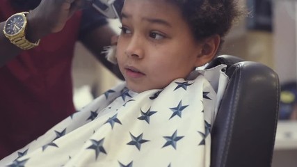 Boy in the african barbershop. Cute mixed boy makes a haircut in the African salon. Hair style. Haircut by machine for children. School boy hair style. Haircut 