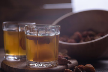 close-up of compote in glasses with a wooden bowl filled with assorted dried fruits