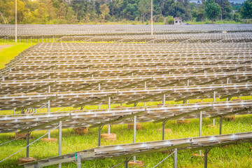 Large scale solar farm, mega photovoltaic power plant in green grass field.
