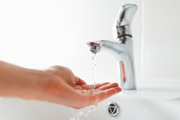 hand under faucet with water stream