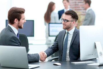 Successful managers shaking hands after closing deal in office