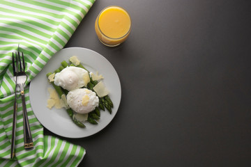 Asparagus salad with poached egg and parmesan cheese. gray background. Healthy, tasty breakfast. Copy space.