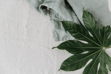 Flat lay  layout made of tropical leaves, on linen napkin. Minimal lifestyle concept . top view