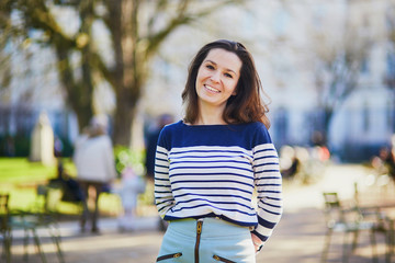 Happy young woman walking in the Luxembourg garden of Paris