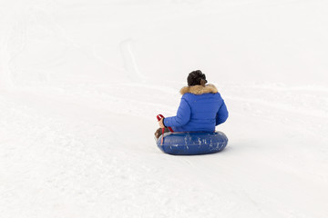 winter, leisure, sport, friendship and people concept - group of happy people sliding on the snow inflatable chambers