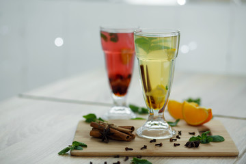 two glasses with colored hot drinks from which steam comes. winter hot seasonal vitemin drinks