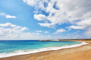 Fototapeta na wymiar Beautiful wild beach with clear turquoise water and waves.