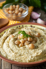 Delicious homemade hummus pasta with olive oil and chick-peas. Wooden table. Healthy food.
